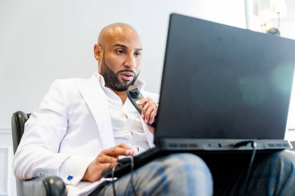 Black Male Radiologist Doctor Reading X ray Images on Laptop from Home